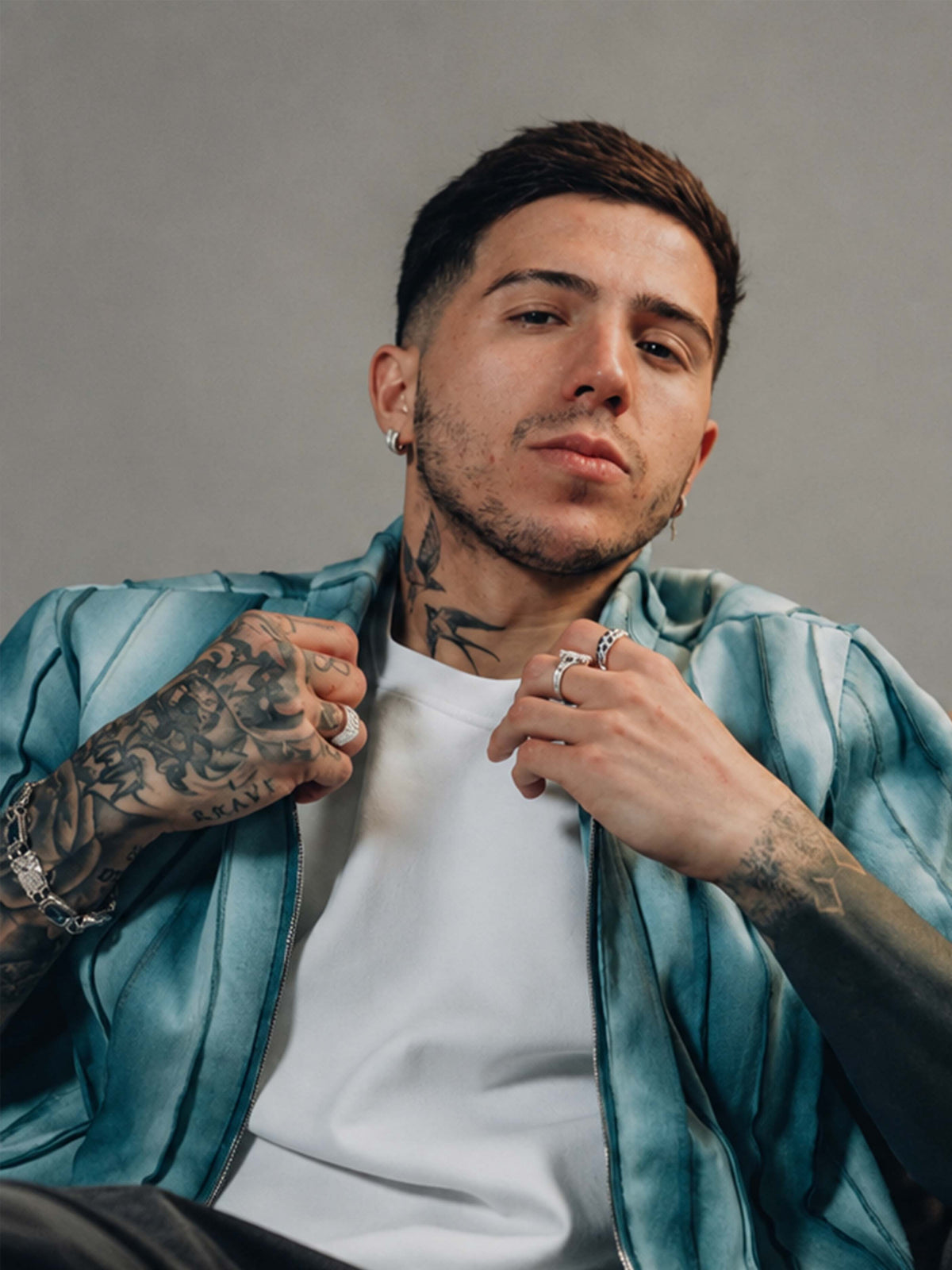 Enzo Fernandez sitting down wearing BRYDER shirt in fashion shoot, close up, texture, detail.
