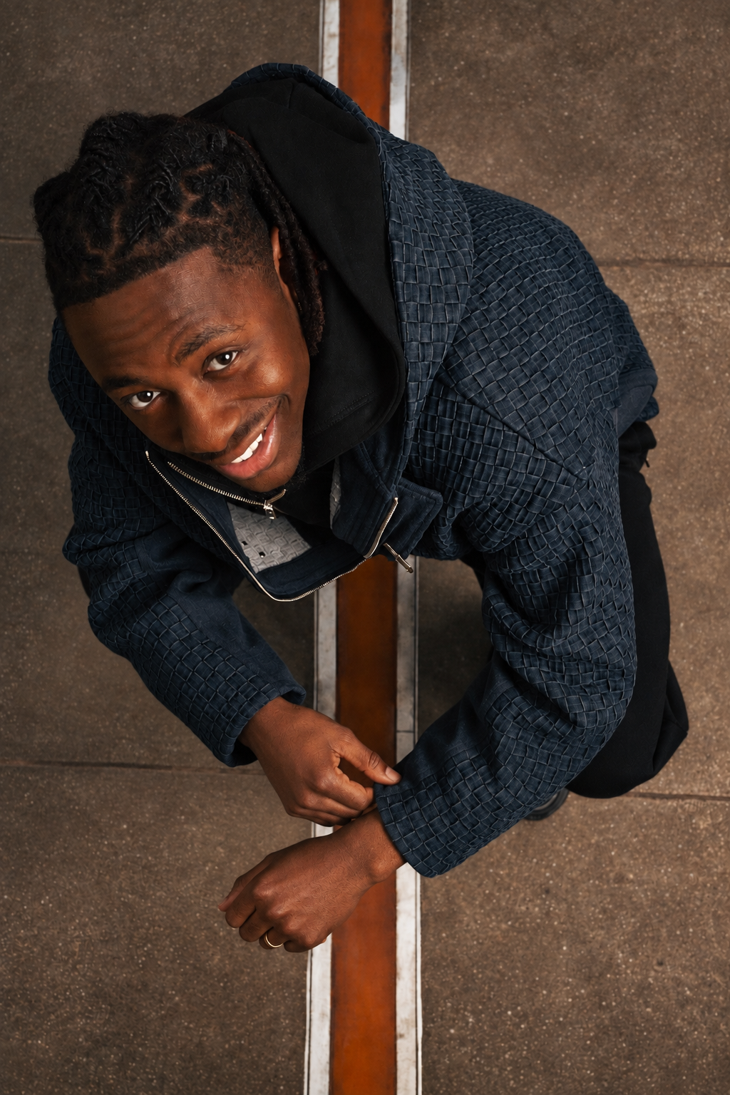 Eberechi Eze wears BRYDER woven denim jacket in fashion shoot in London. Overhead shot